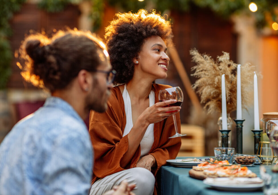Group of friends socializing at the backyard and drinking wine