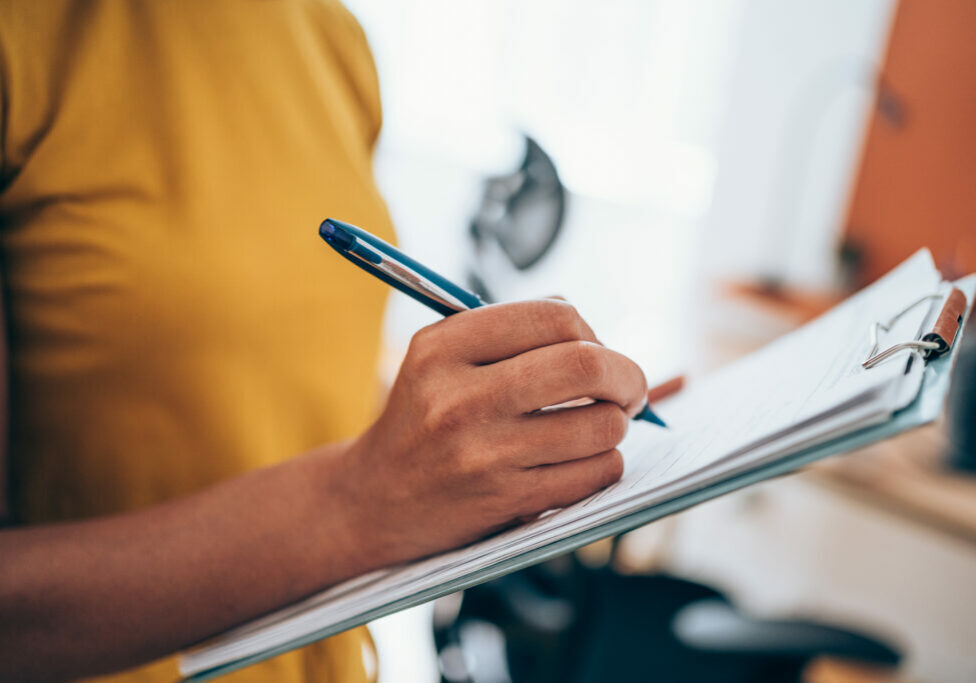 Cropped shot of an unrecognizable businesswoman making notes on a clipboard inside of the office.
