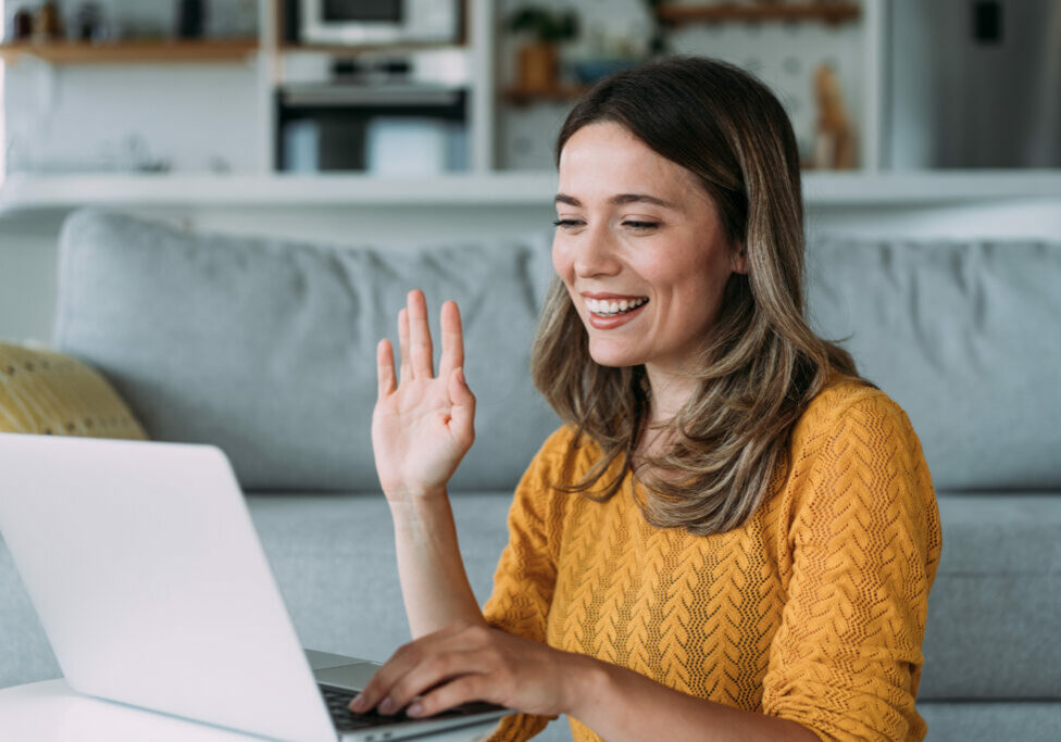 Beautiful young woman having video call at home. Shot of an attractive woman using a laptop for video conference.