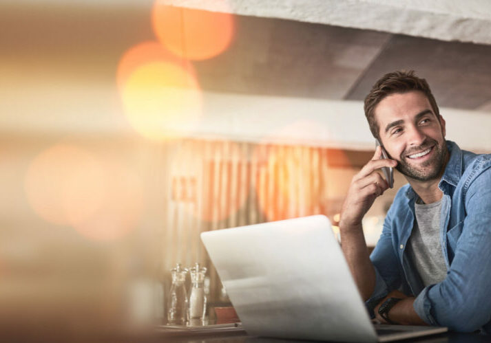 Phone call, laptop and man in coffee shop for remote work, client contact and online connection. Communication, business mockup and freelance male talking, networking and conversation on smartphone