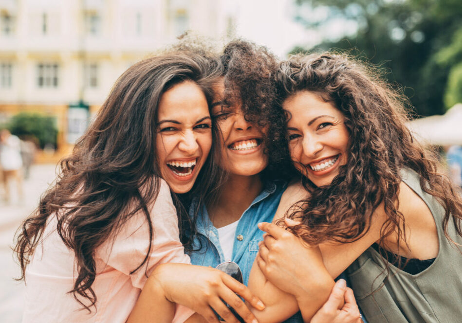 Three best friends hugging each other in the city.