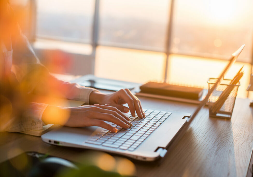 Female teleworker texting using laptop and internet, working online. Freelancer typing at home office, workplace